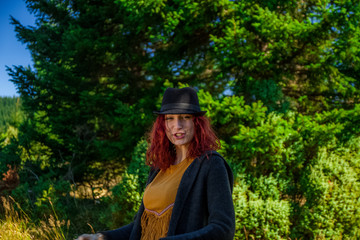 Pretty redhead girl with cowboy hat enjoying the nature and mountain

