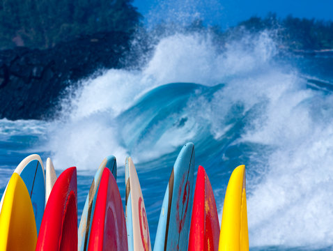 Powerful waves break at Lumahai Beach, Kauai with Surfboards