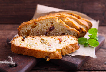 a piece of cake with raisins and candied fruit on a white plate on a blue background