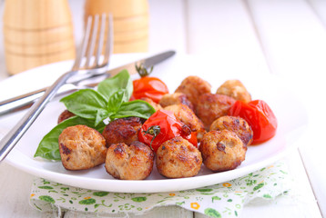 Meatballs with tomato in a white dish on a white background. selective focus.