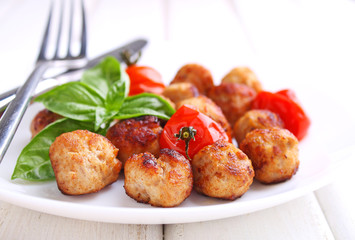 Meatballs with tomato in a white dish on a white background. selective focus.