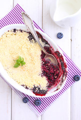 crumble with blueberry, bilberry in white plate on a white background.
