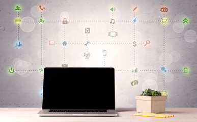 Laptop on office desk with media icons