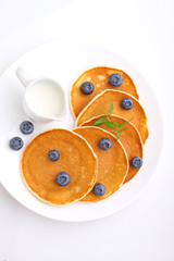 Pancake with berries blueberries in a plate on a white background