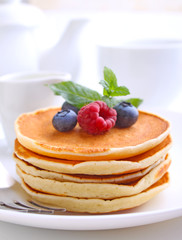 Pancake with berries blueberries in a plate on a white background