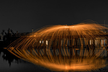 Showers of hot glowing sparks from spinning steel wool.
