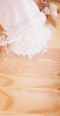 Baking ingredients: flour and ears on a light wooden background