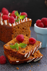 Gingerbread (honey-cake) with raisins decorated with icing, mint leaves and raspberries