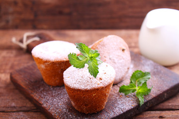 Sponge cakes with raisins decorated with powdered sugar and mint leaves