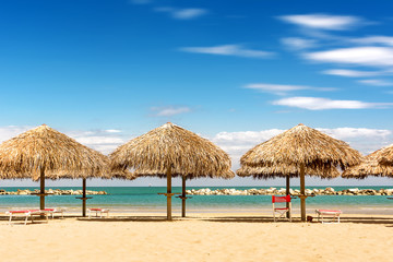 Fototapeta na wymiar Palm parasol on the beach in a sunny day