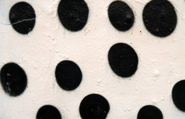 Weiße Mauer mit schwarzen Punkten