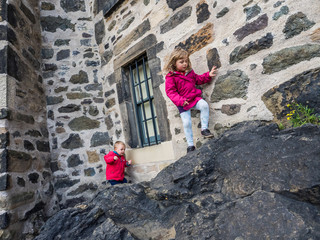 Little boy and girl climbing rocks