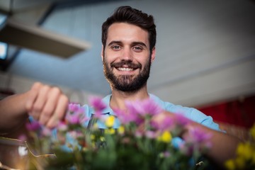 Portrait of male florist preparing flower bouquet