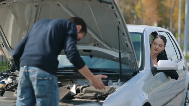 Man repair broken car for a woman