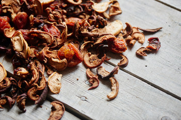 Set of dried fruits of apples, apricots and raisins lying on a wooden table closeup