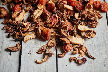 Set of dried fruits of apples, apricots and raisins lying on a wooden table closeup