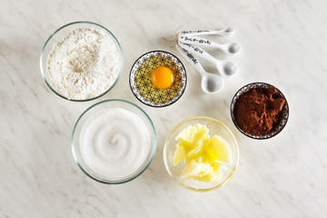 Ingredients for baking on a white marble table : flour, eggs, co
