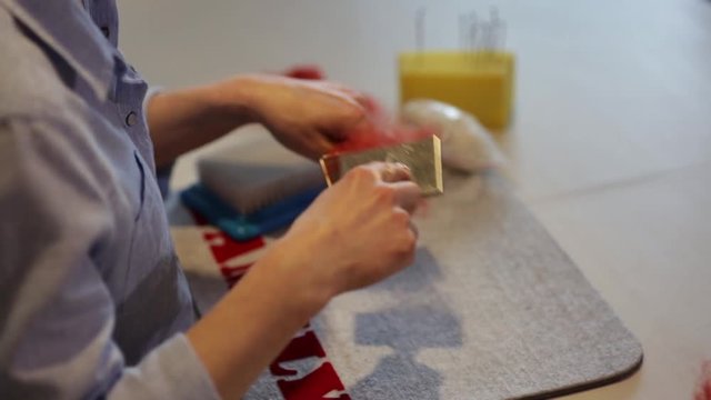 Чесание волокон окрашенной шерсти ручными кардами в процессе работы по изготовлению войлочного изделия