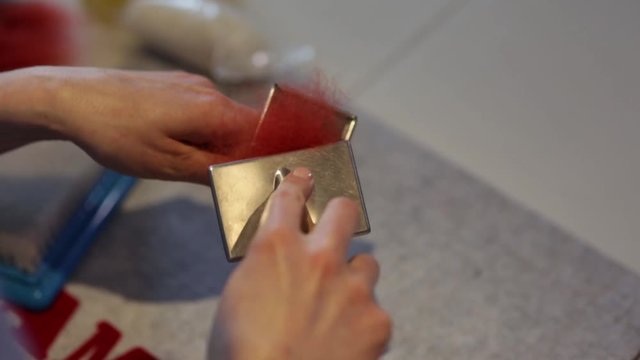 Чесание волокон окрашенной шерсти ручными кардами в процессе работы по изготовлению войлочного изделия
