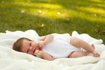 Obraz na płótnie Canvas Baby lying on the blanket on the grass