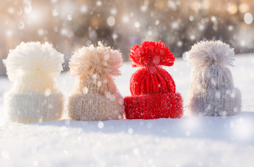 Woolen knitted hats on snow. Hello winter! Holiday background