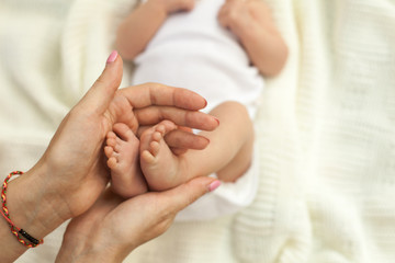 Fototapeta na wymiar Hand holding little baby's legs