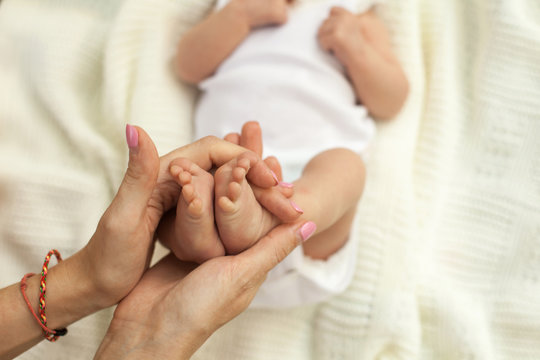 Hand holding little baby's legs