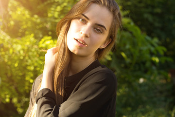 Fototapeta premium Young woman on the background of trees and sunlight 