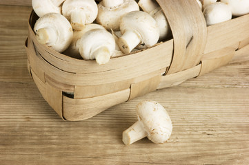 Basket with mushrooms on wooden background