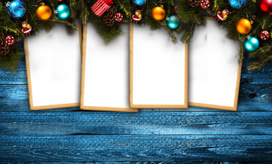 Merry Christmas Frame with real wood green pine, colorful baubles, gift boxe and other seasonal stuff over an old wooden aged background