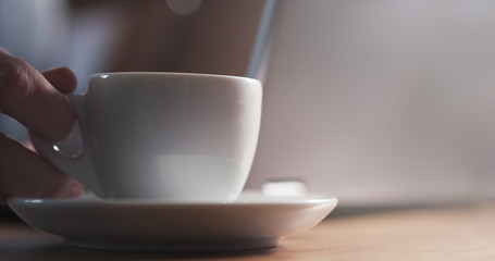 young man working on notebook in cafe and coffee shallow focus