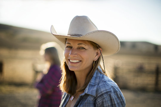 Portrait of a smiling rancher wearing a cowboy hat while out on the ranch.