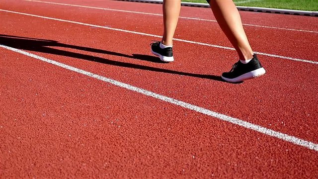 Tracking camera of the shoes of a track runner athlete woman running in a line