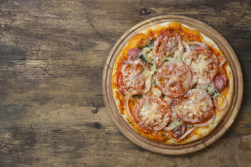 Rustic pizza with salami, mozzarella, olives and basil top view, Fresh homemade salami pizza on wooden with copy space 