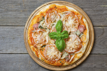 Rustic pizza with salami, mozzarella, olives and basil top view, Fresh homemade salami pizza on wooden with copy space 
