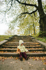 Little girl in the autumn park.stairs.