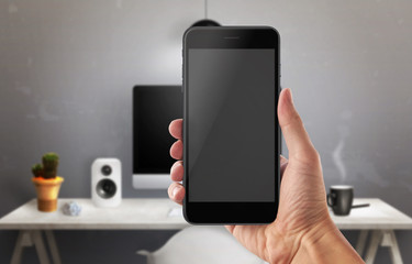 Man holding smart phone in office. blank screen for app promotion.