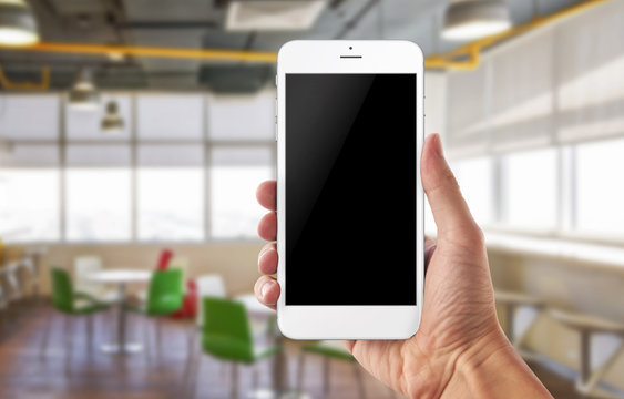 Smart phone in man hand. Office background. Blank screen for app promotion.