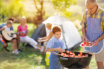 happy family grilling meat on a barbecue.