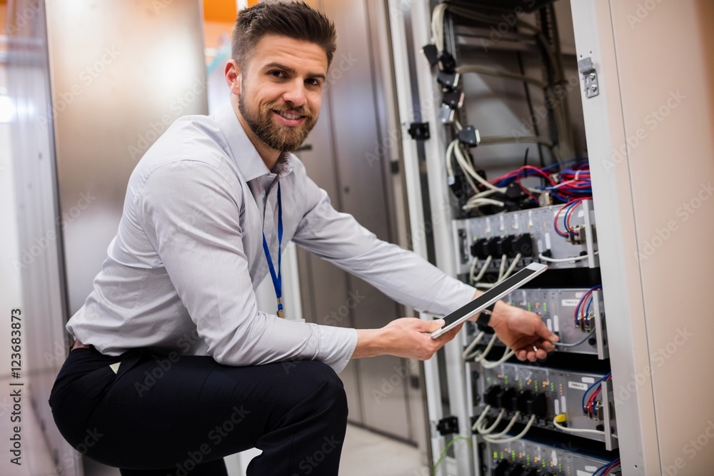 Aufkleber Technician using digital tablet while analyzing server