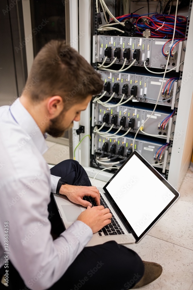 Aufkleber technician using laptop while analyzing server