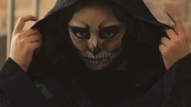 The witch looking on the camera from under the black coat. Slow motion