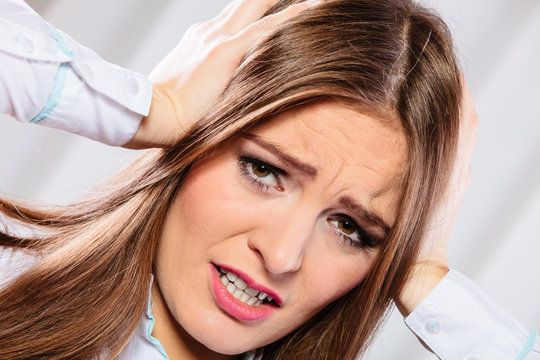 stressed woman in white shirt with headache