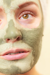 Woman face with green clay mud mask