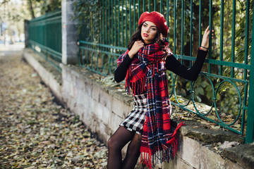 Plakat Beautiful happy girl in red hat and scarf walking in the autumn park