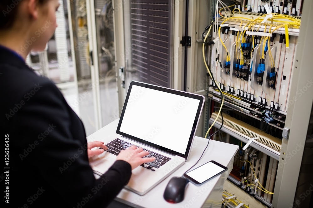 Aufkleber technician using laptop while analyzing server