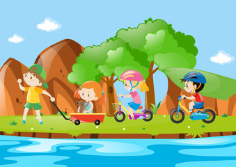 Children in cart and on bike along the river