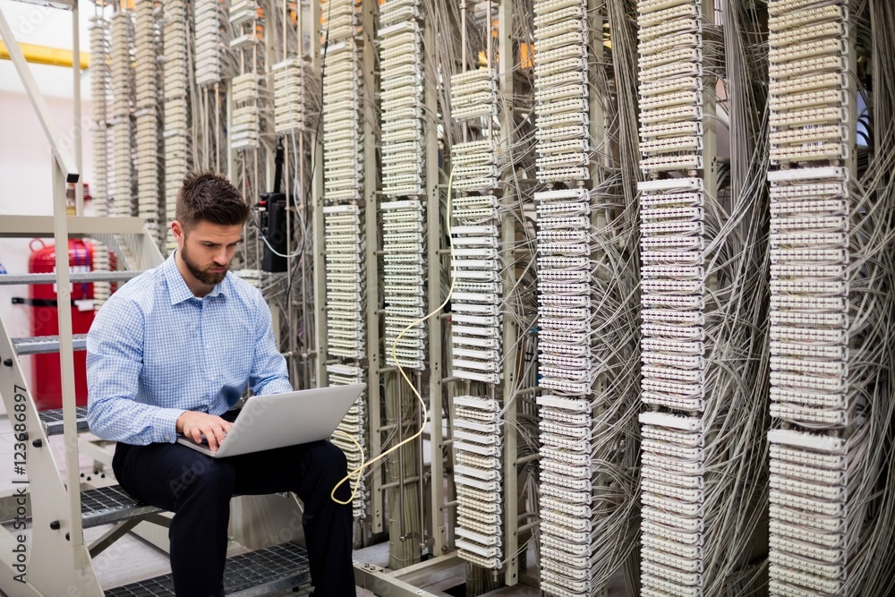 Aufkleber technician using laptop while analyzing server