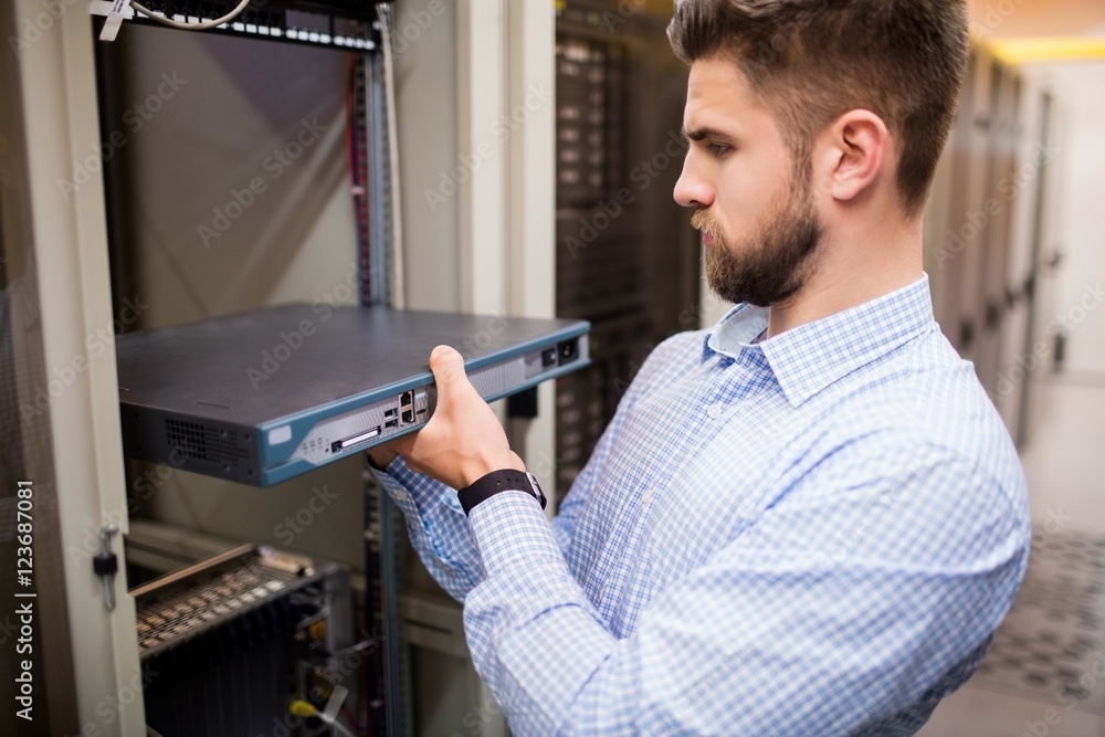 Poster technician removing server from rack mounted server