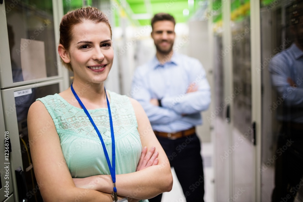 Poster technicians standing with arms crossed in a server room